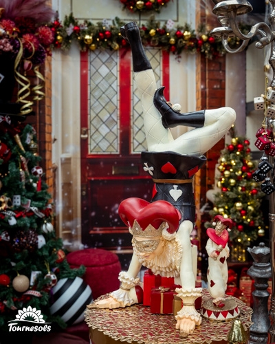 Décoration de Noël avec figurine de bouffon acrobate et arbres illuminés.